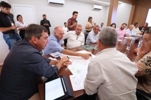 Govenador, secretário Hélio Peluffo e prefeito Sonora olham para projeto de obras na cidade