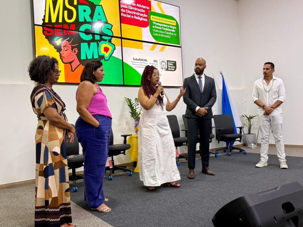 >Integrantes do GTI, Irinéia Cesário, Giselle dos Santos, Myla Meneses e Fabrício Dias, junto ao subsecretário de Políticas Públicas para Promoção da Igualdade Racial, Deividson Silva. (Foto: Matheus Carvalho/SEC)